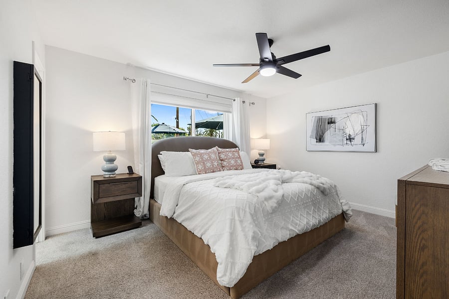 The primary bedroom is a peaceful retreat with soft tones, plush bedding, and natural lightperfect for unwinding after a day in the sun.
