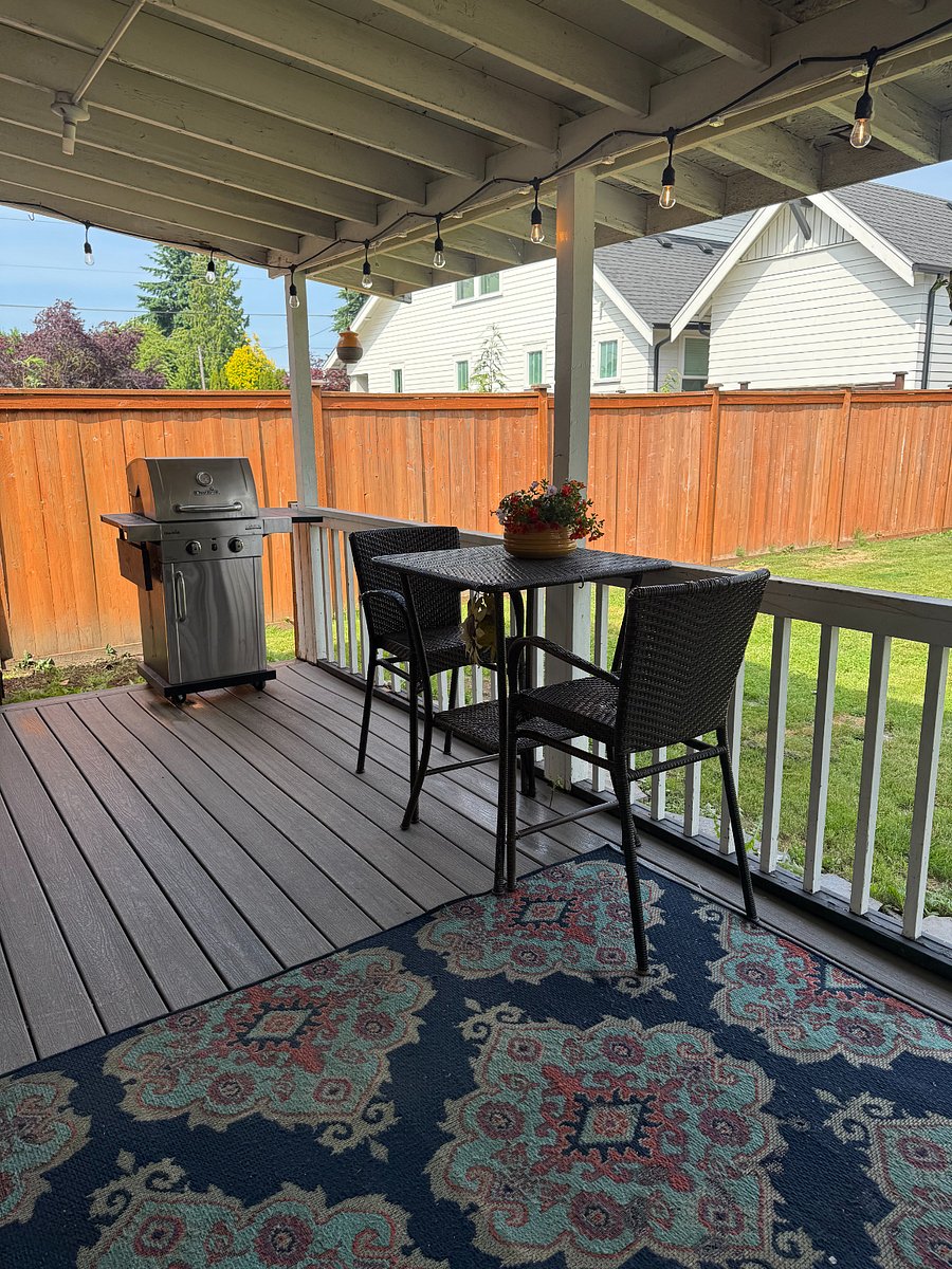 Spacious covered patio with seating, BBQ, patio swing, and outdoor fridge.