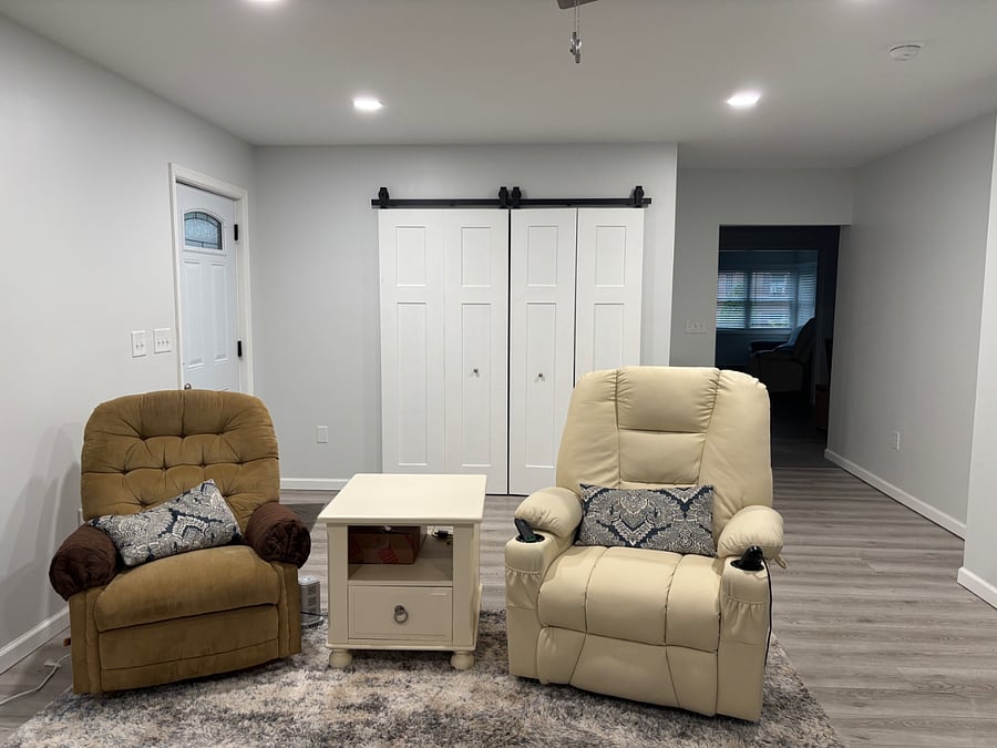 Shared common area with television. Washer and dryer located behind sliding barn doors. Unit 1 with queen size bed and private bath is located beside this area.