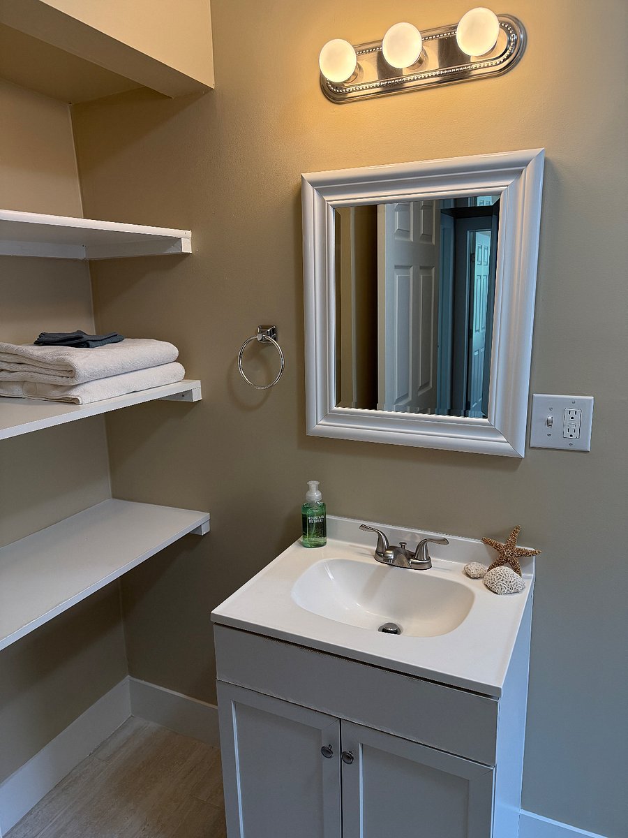 Full bathroom with shelving storage