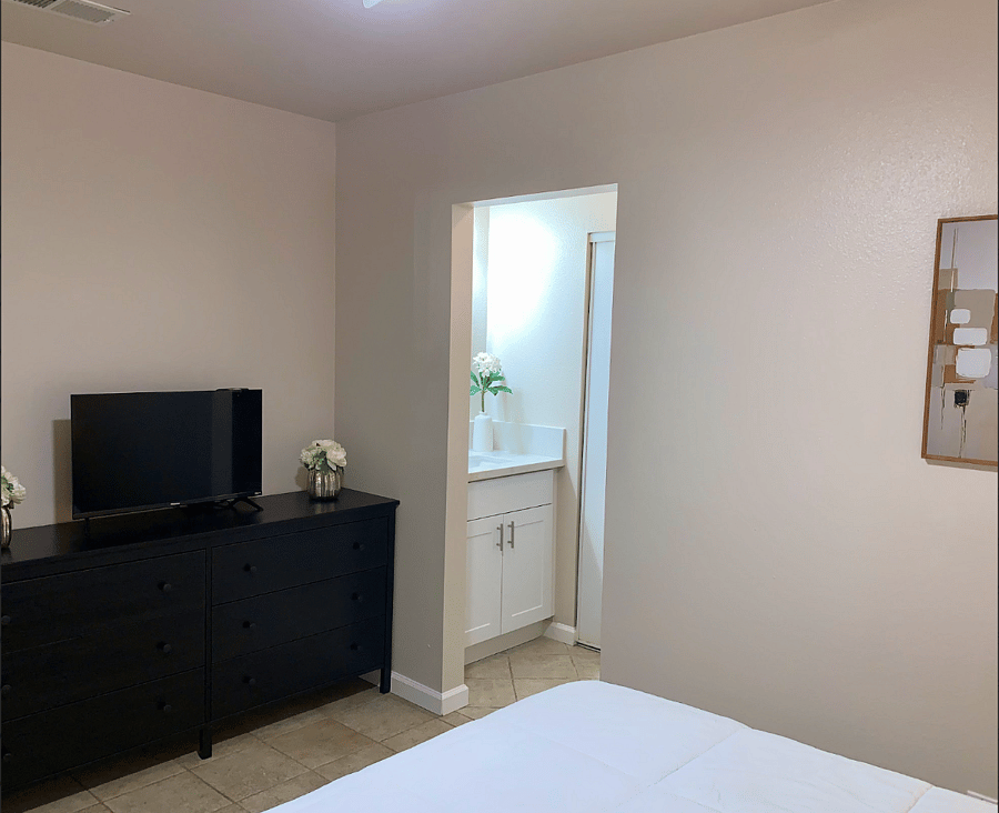Matching nightstands with drawers provide convenient extra storage, while a spacious dresser offers plenty of room for your belongings. The space is located adjacent to the vanity area, making morning routines easy and efficient.