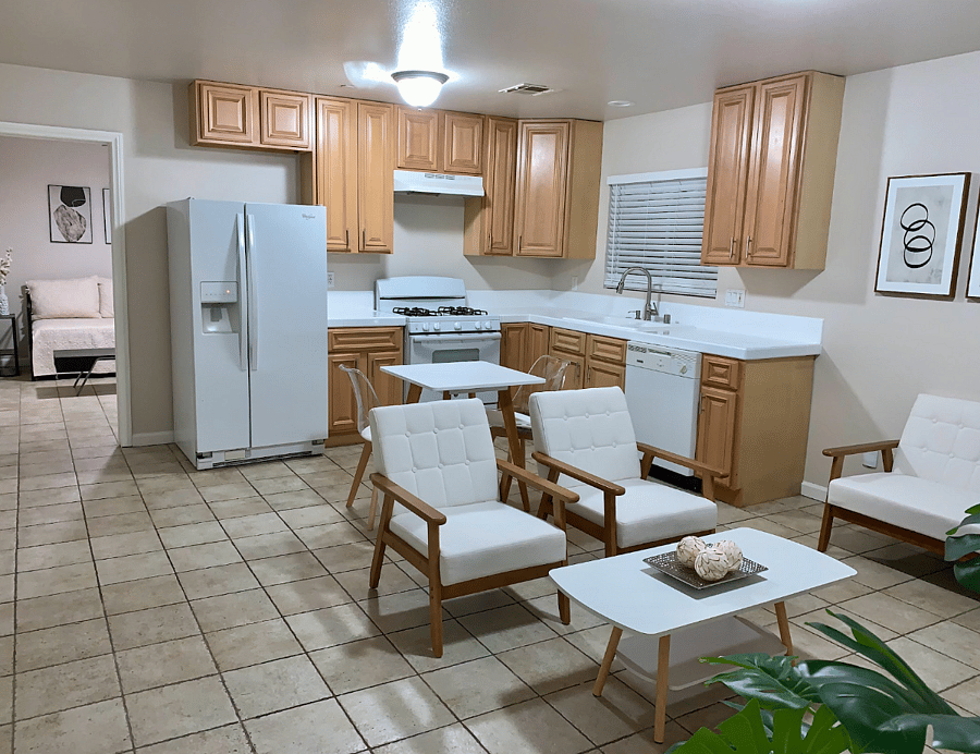 Kitchen fully stacked with dishes, cooking utensils. Refrigerator, gas stove, and dishwasher.