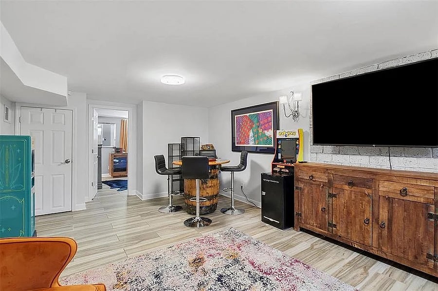 Lower level den with couch and large TV.
