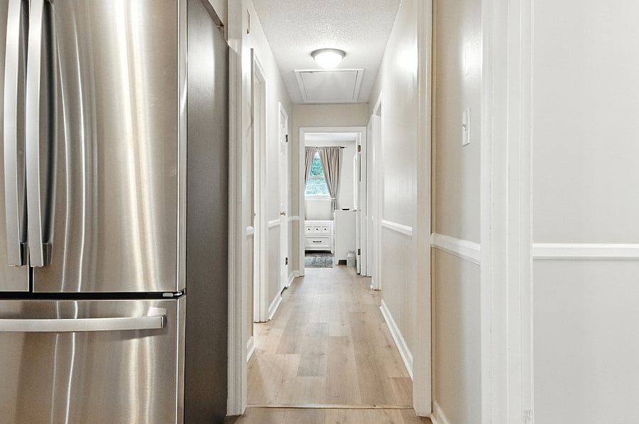 The shared hallway bathroom is on the left, with two bedrooms on the right, and the main bedroom with an en suite bathroom is straight ahead.