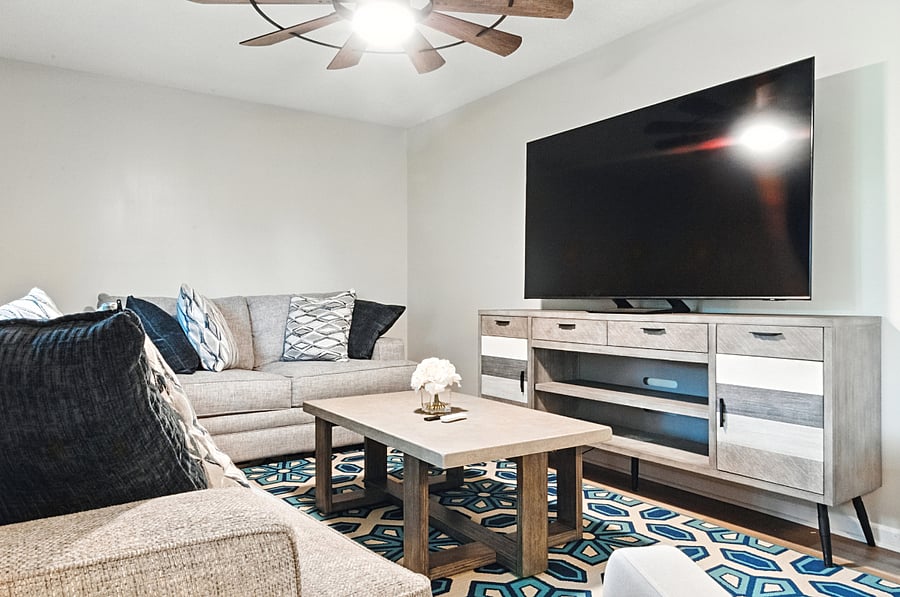 The living room features a brand new 75" Samsung QLED Smart TV with 120 Hz refresh rate, supported by blazing fast 500 Mbps wifi internet, perfect for gaming.