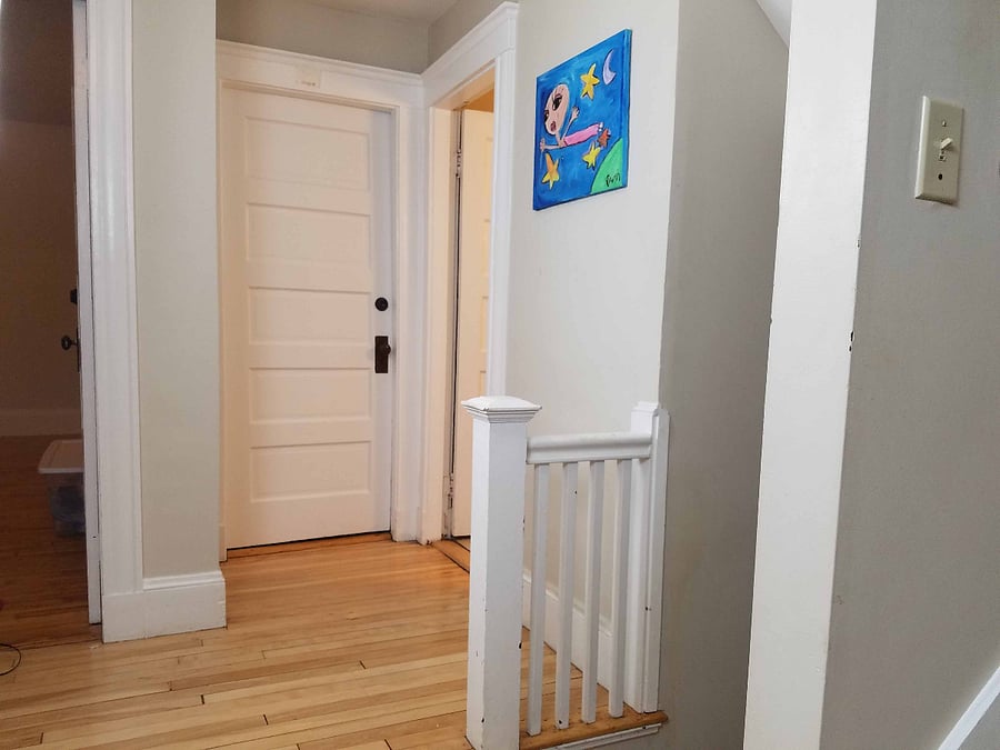 Hallway outside the rooms on 2nd floor focused on the bathroom door to the right.