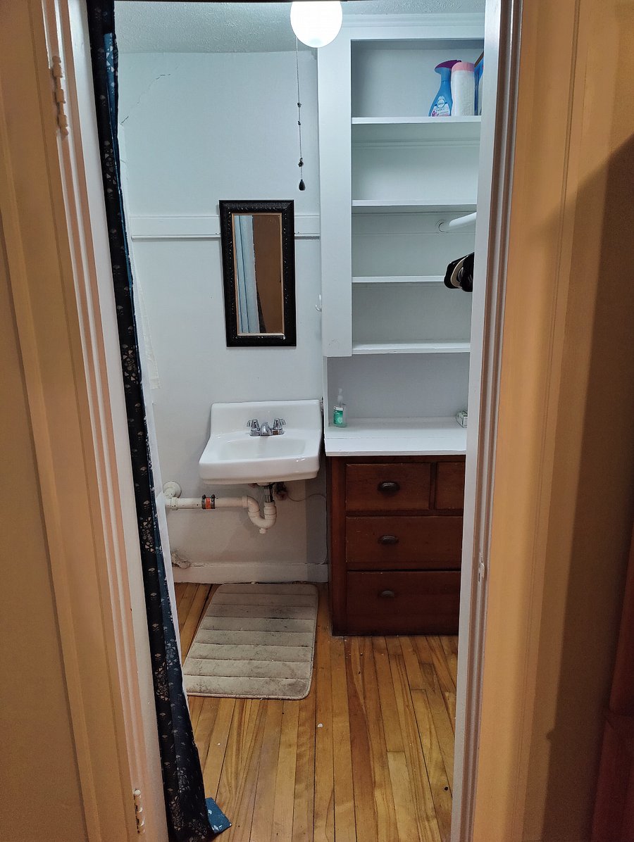 12'x12', Queen bed, armoire, walk-in closet with drawers and sink, desk and chair, side table, lamps.