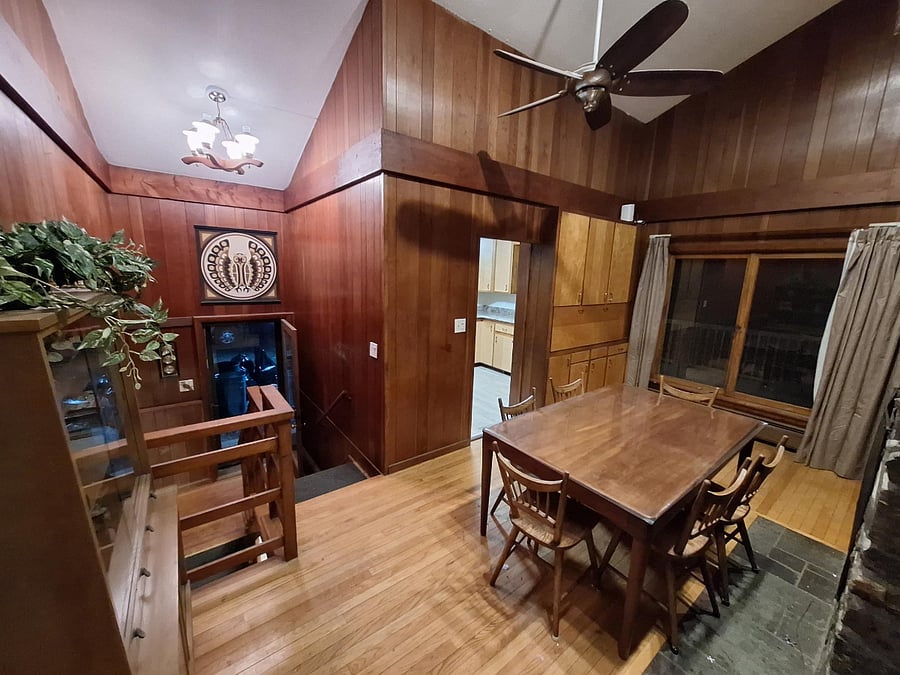 Dining space leading to kitchen and stairs down to carport entrance and lower level.