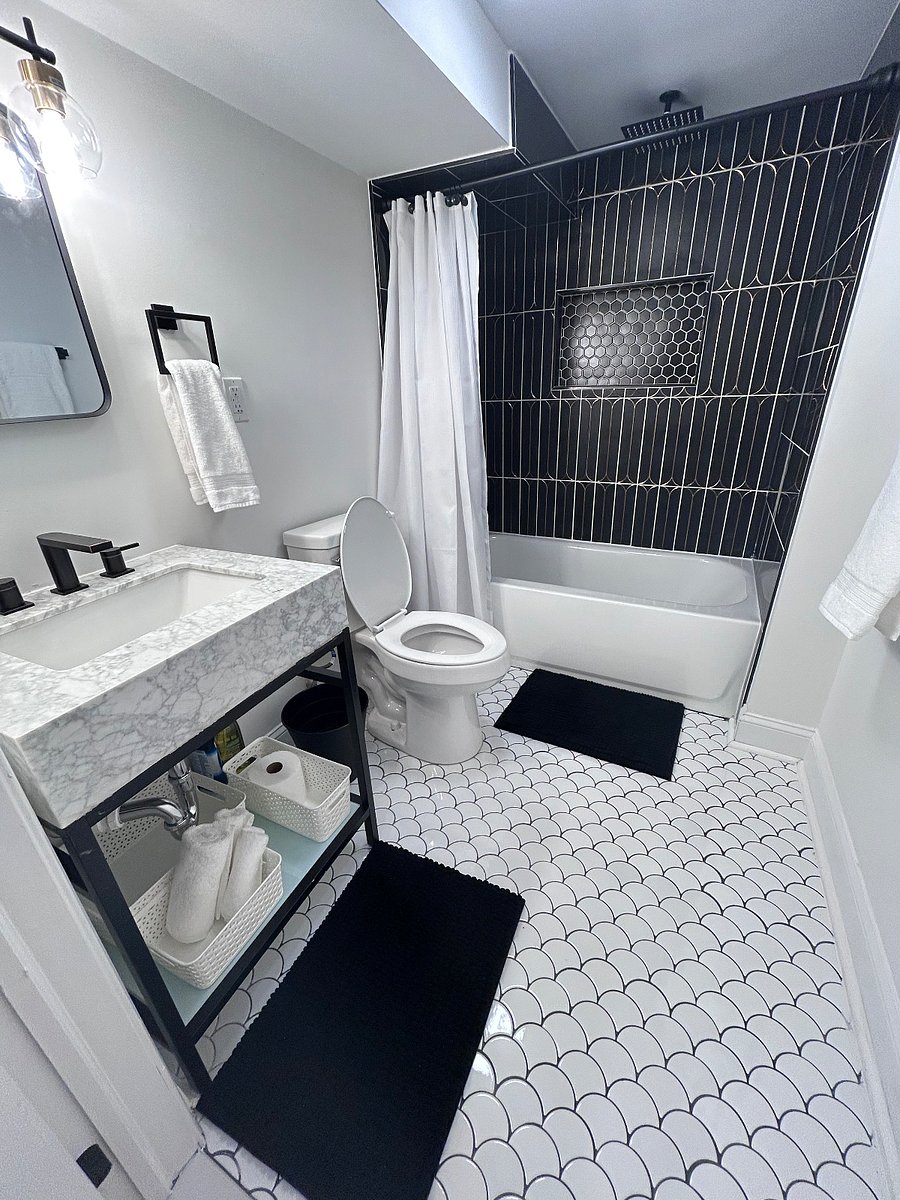 Bathroom with High-End Finishes. Marble accents and custom tilework, the space includes a bathtub with both a rainfall and detachable showerhead.
