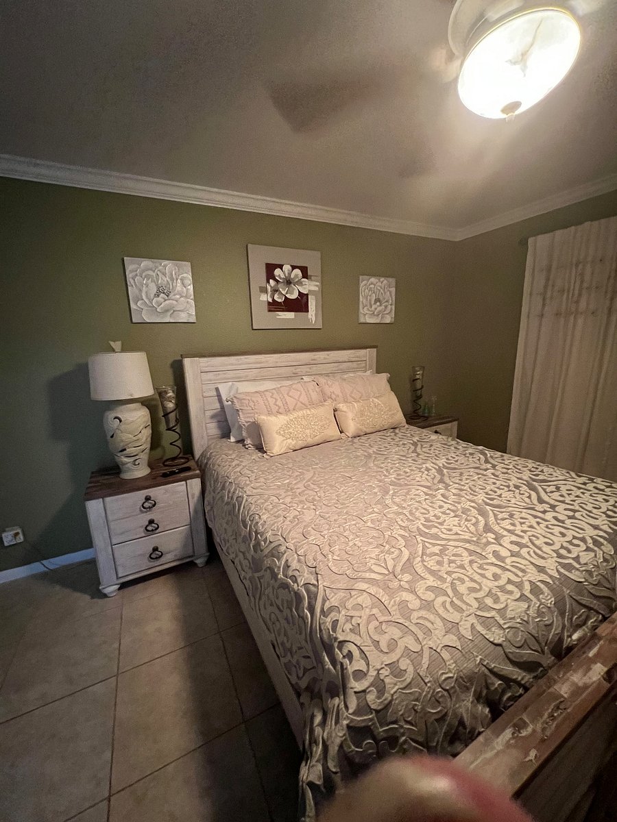 Primary bedroom with TV, dresser & calming decor.