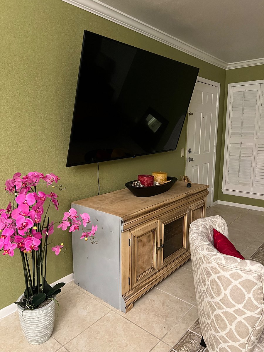 Wall-mounted TV and accent chairs for entertaining.