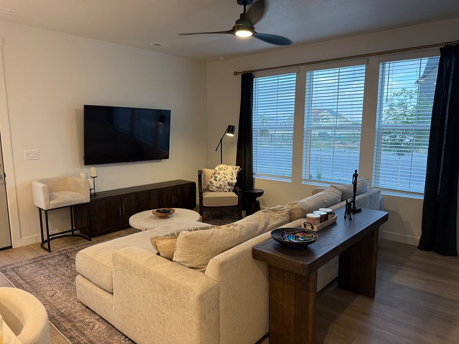 Living room with 65" TV, Pottery Barn sectional, large windows and ceiling fan