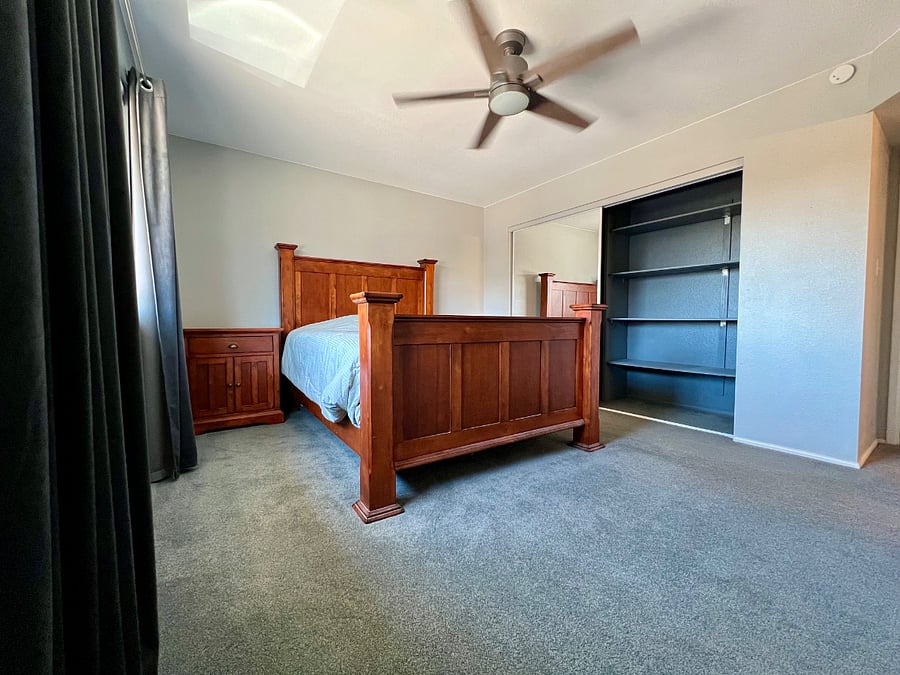 Primary bedroom. Built-in shelving in the closet with other half of closet with dowel rod to hang clothes.