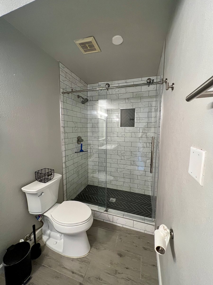 Recently renovated walk-in shower with floor-to-ceiling tile.
