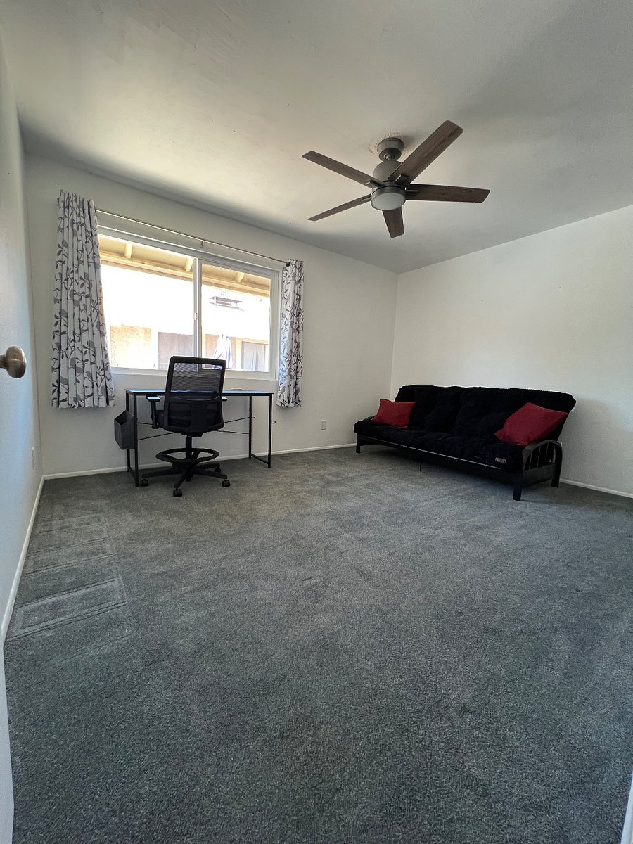 Guest bedroom/office or workspace with futon and blackout curtains.