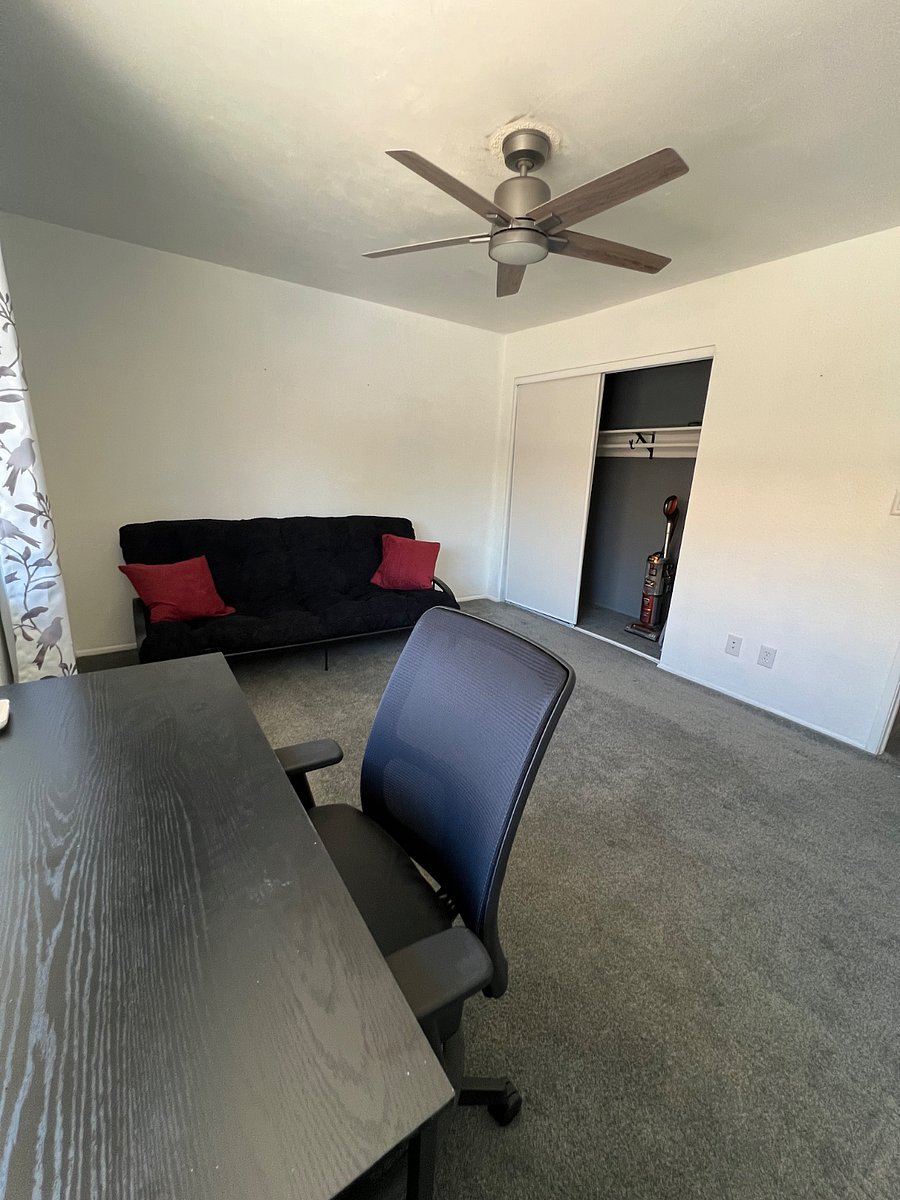 Guest bedroom with decent closet space with vacuum and iron/ironing board in closet.