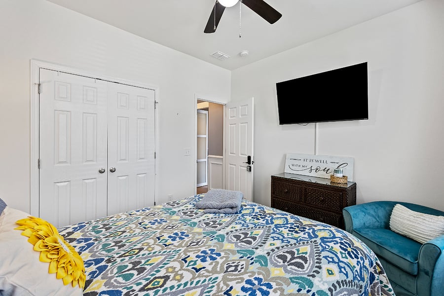 Guest bedroom include 55 inch smart TV. With cozy reading chair, and soft natural light.