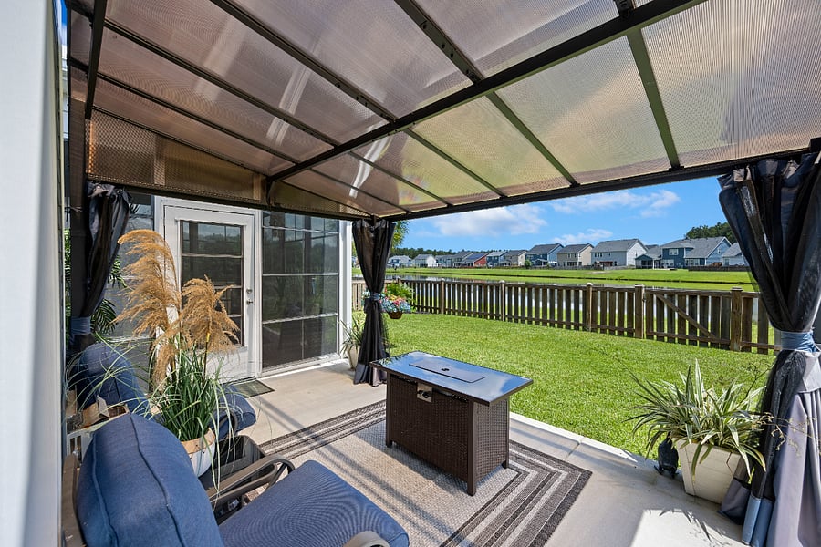 Unwind under the shaded patio with peaceful views of the pond and neighborhood skyline. Whether you're sipping your morning coffee or enjoying an evening breeze, this cozy outdoor space is made for relaxation.