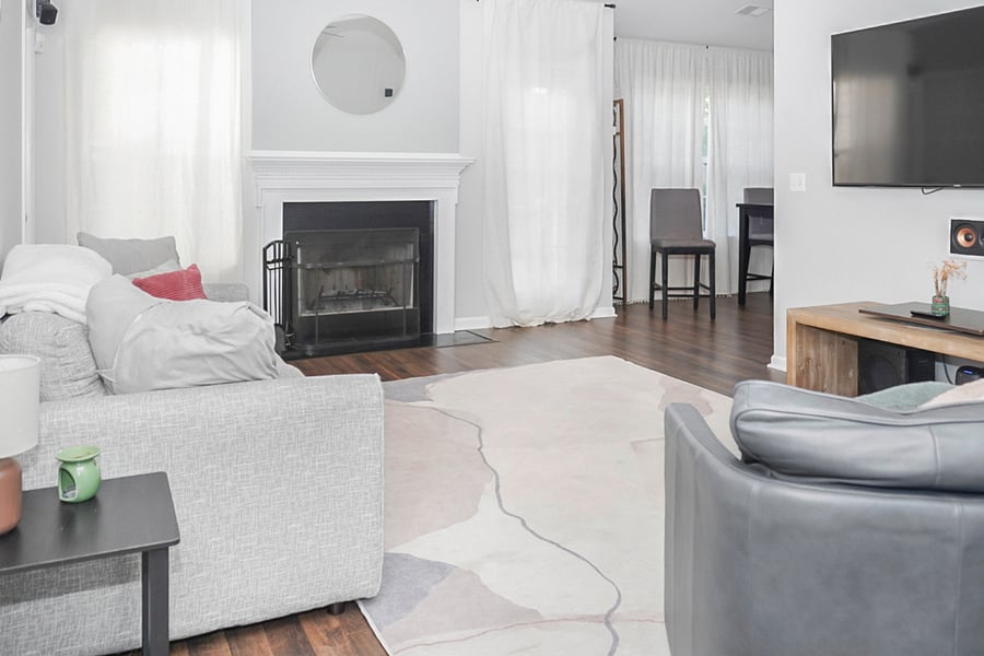 This inviting living room features a beautiful fireplace and plenty of natural light, creating a warm and welcoming atmosphere. Its the perfect spot to unwind or enjoy quality time with loved ones.