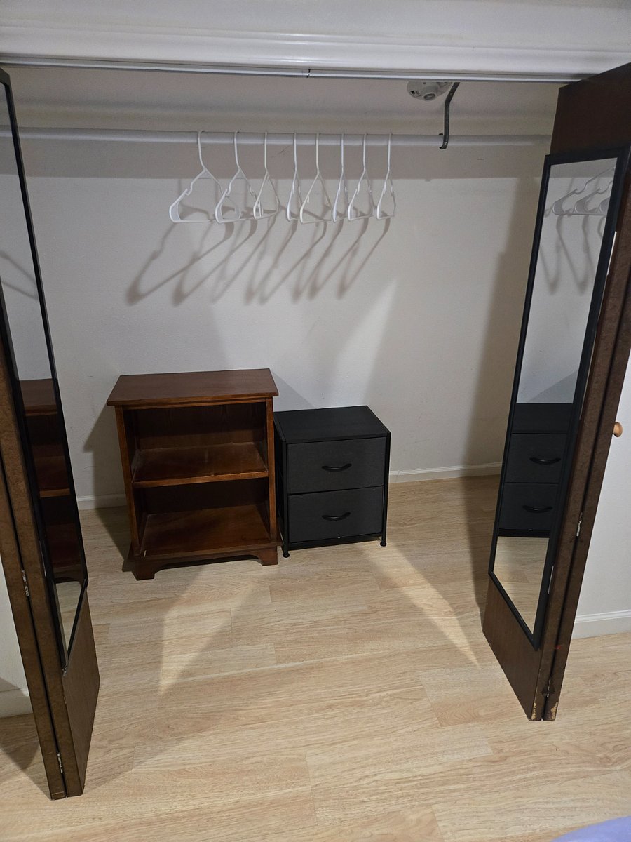 A closet with 2 drawers and some extra shelving.