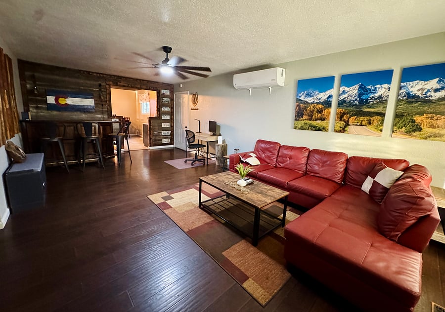 Spacious living room with sectional, office space and bar w/ stools