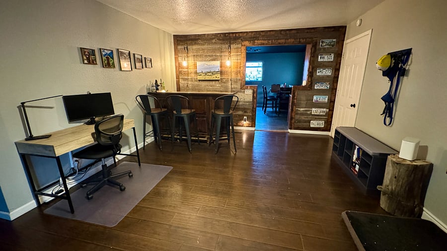 Family room space includes a work station, bar top and bench with shoe rack