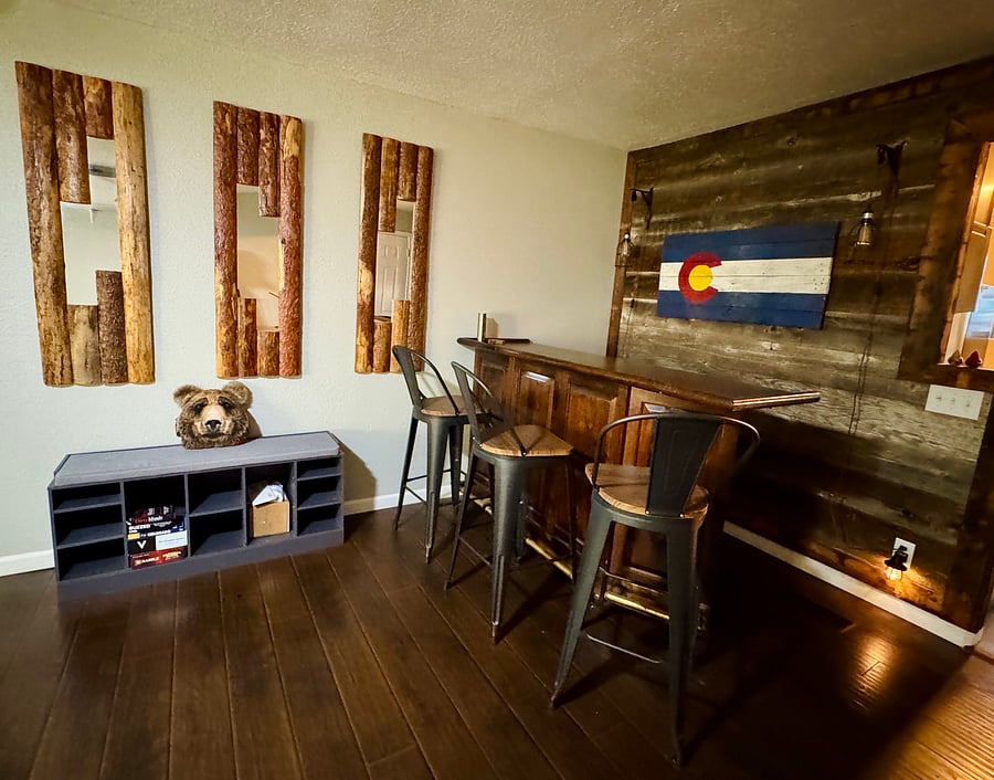 Bar area with additional seating and reclaimed wood wall