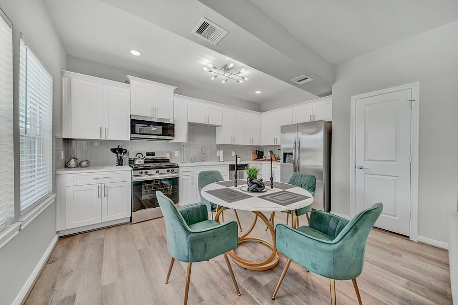 The ceiling is equipped with recessed lighting, and there is an additional decorative light fixture above the dining table, adding a touch of elegance to the room.