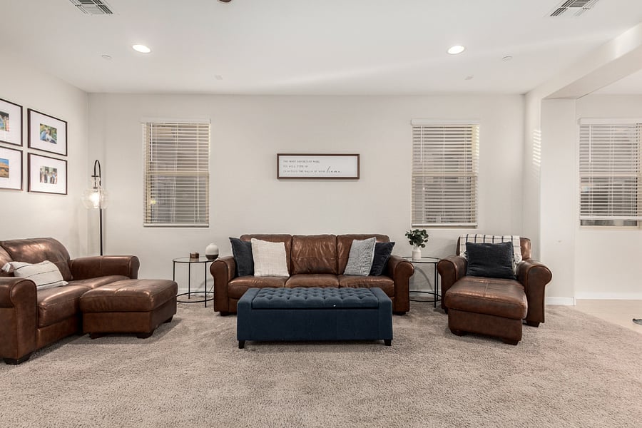 living space with leather furniture, artwork, and natural lightgreat for reading or unwinding.