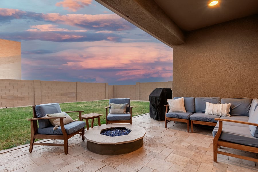 Covered backyard patio with fire pit seating and comfy outdoor furnitureideal for Arizona evenings.
