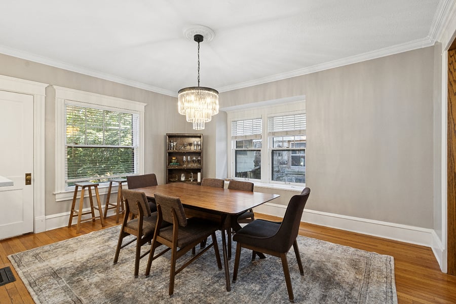 Dining room with table for six and three barstools for the counter.