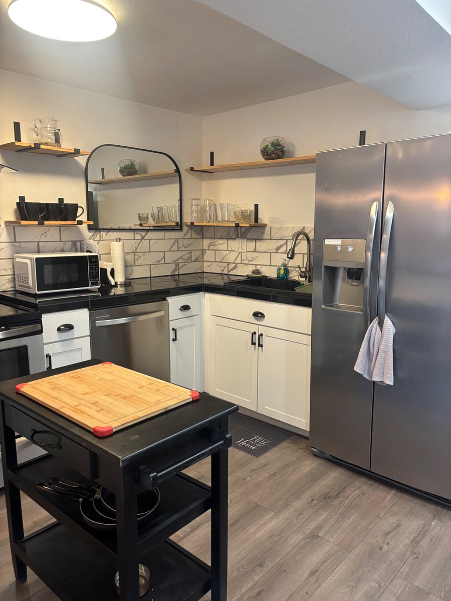 Large sink, black granite counter tops and stainless frig with exterior ice maker and water diapenser.