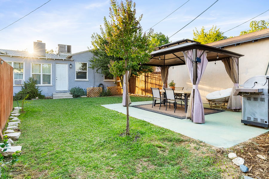Fully Fenced backyard with BBQ grill, Solar Edison lights, and dining area