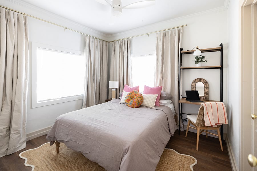 bedroom #1 with windows to the frontyard/street and blackout curtains with blinds. This room also includes a small wall desk and work area.
