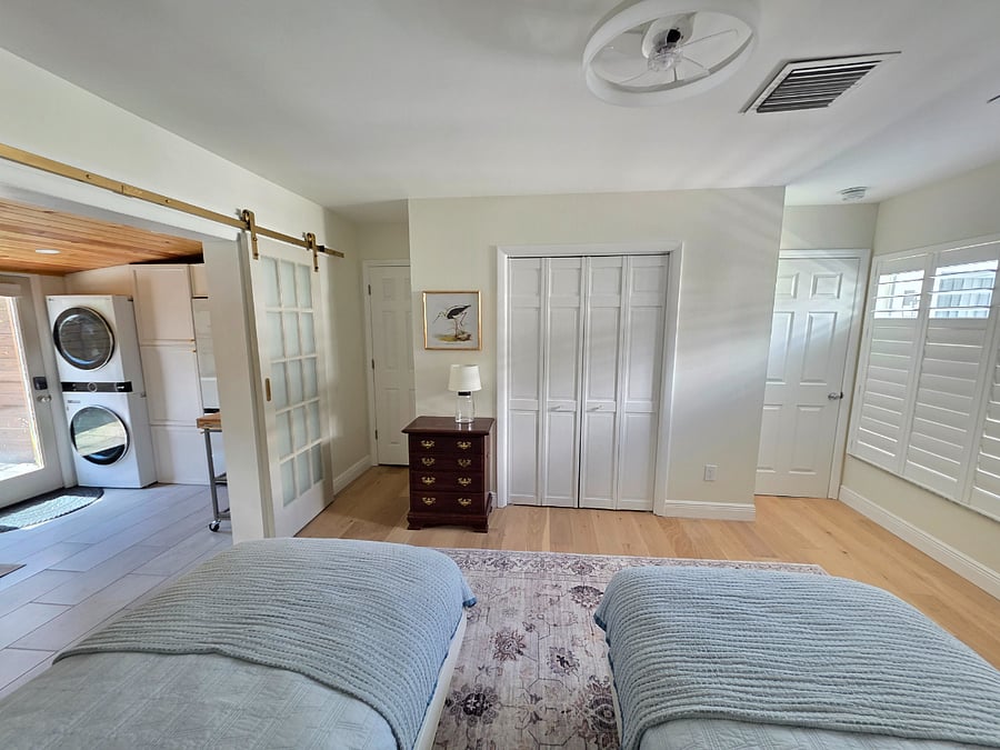 Second bedroom view from beds, extra storage space or space for pet bed in front of double solid locked doors to the right