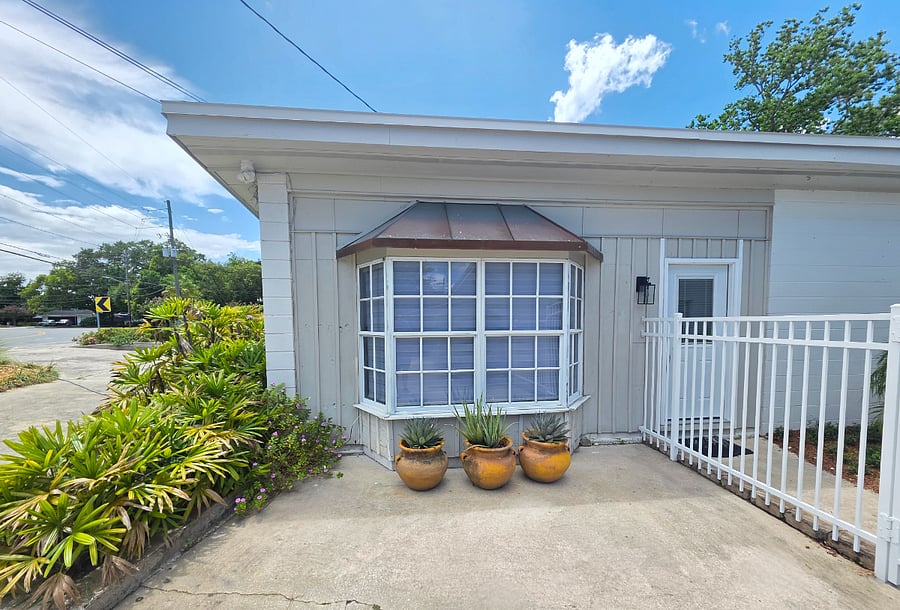 Exterior view of copper roof bay window and enclosed/gated courtyard door.