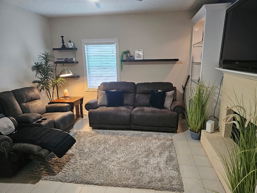 Spacious living and media room with fireplace and built-ins. Comfortability for rest, quiet evenings, and decompression.