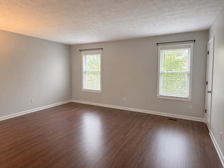Empty second bedroom showcasing natural light and a spacious layout comfortably accommodates a queen or king bed.