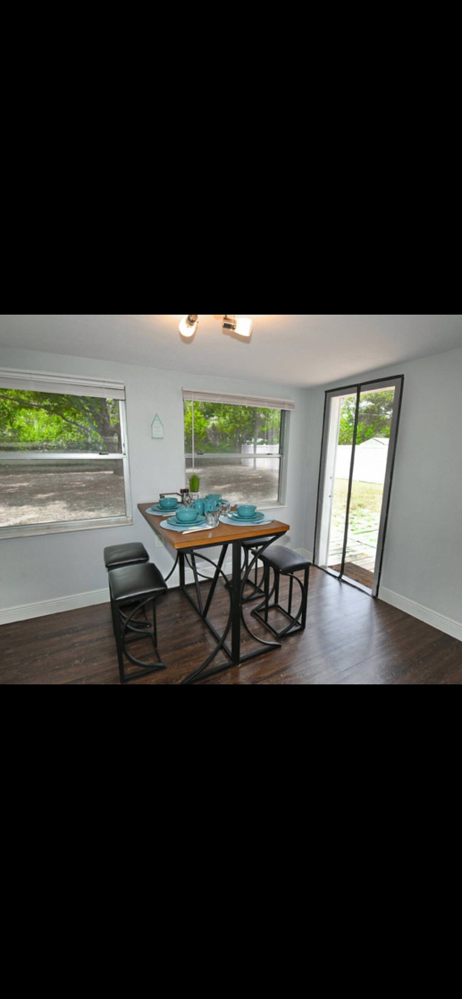 Dining room table and a view of the backyard to watch your dog or kids play. Dining room with dim lights.