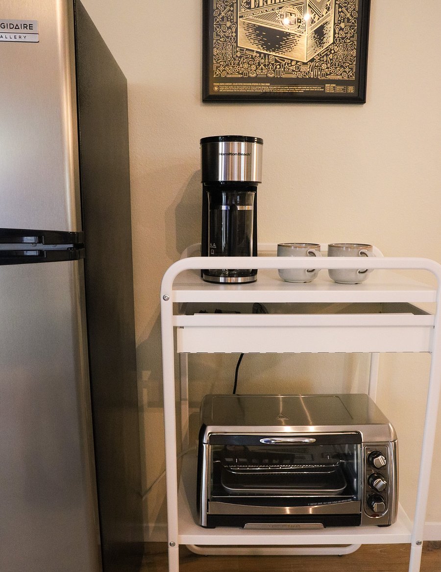 Coffee maker and toaster next to the fridge.
