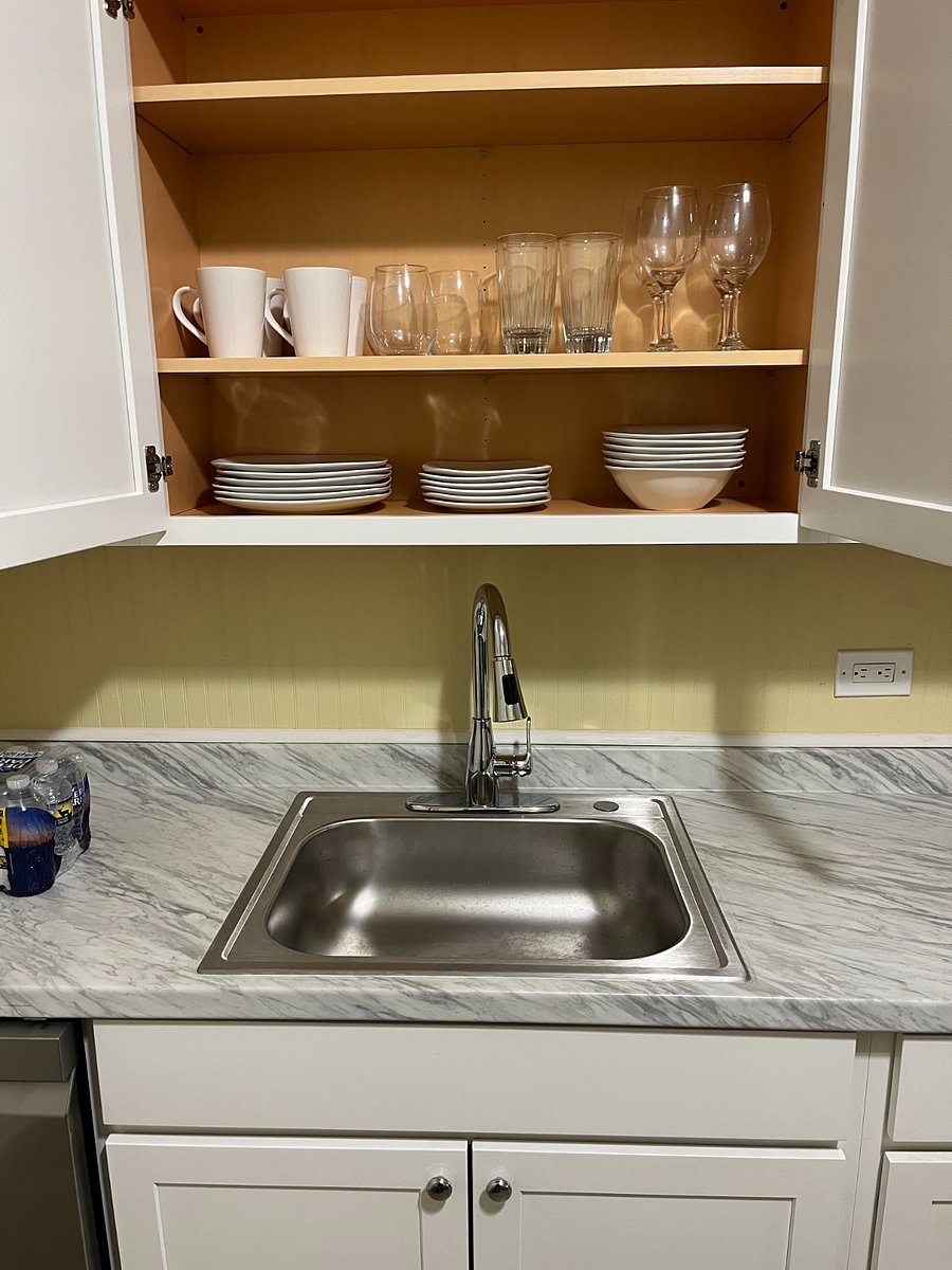 Kitchen sink and cabinet with plates and cups