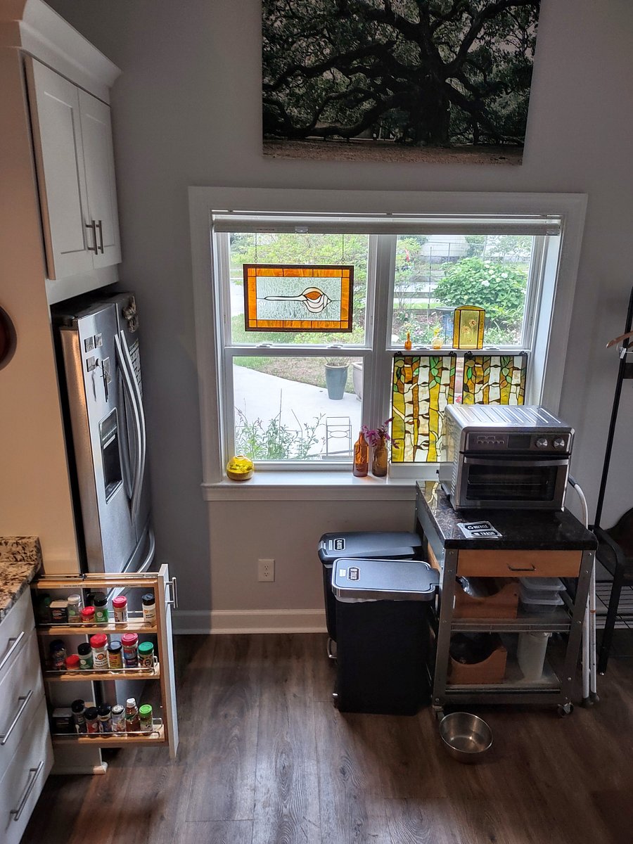 Recycle bin, Loaded spice rack, stain glass accents, custom shade and a garden view.