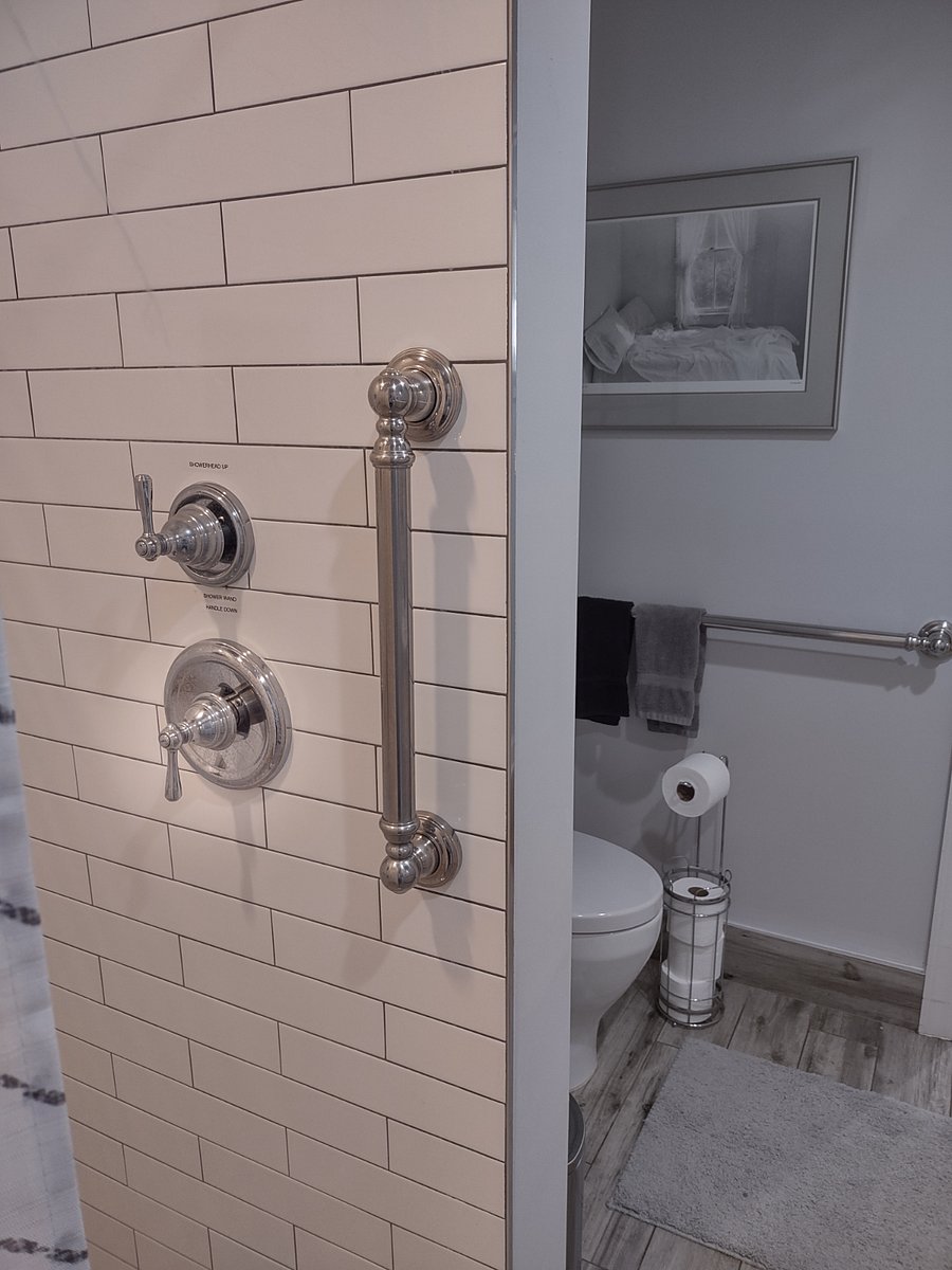 Tall commode and large walkin shower with handrails.