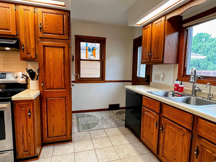 A backdoor opens onto a deck and the backyard, and there is also a door from the kitchen down to the finished basement.