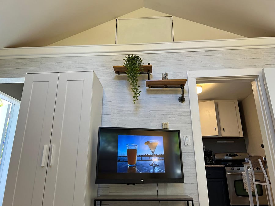 TV and storage closet, view into the kitchen. View of high ceiling in front room. 

