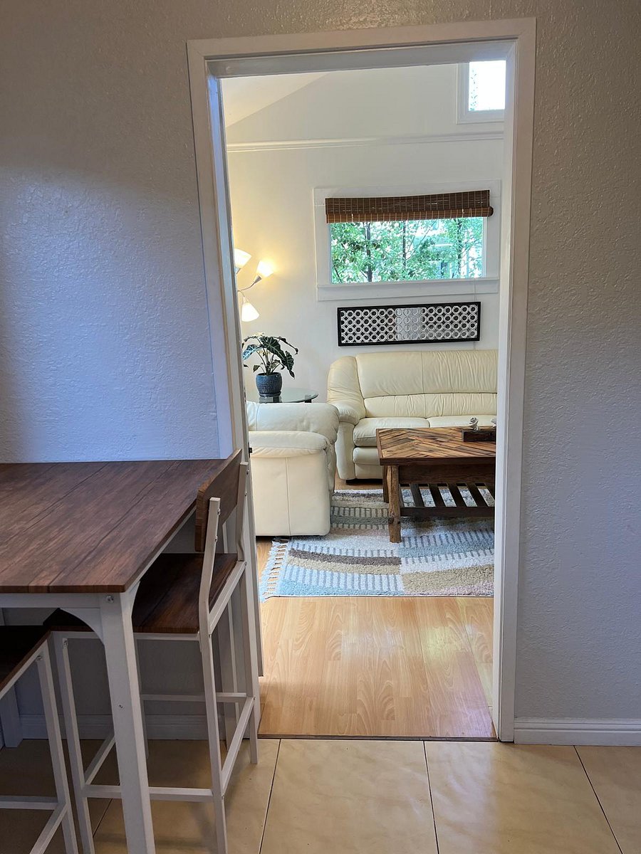 View of main room from kitchen. Kitchen table and 2 stools on the left. 