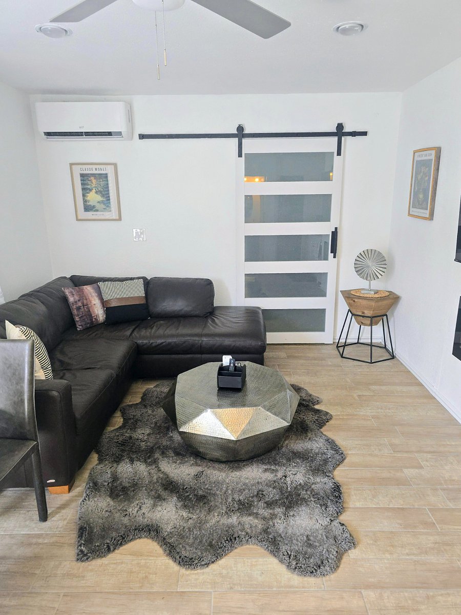 Living room with bear skin rug, genuine leather sectional and barn doors leading to the master bedroom. 