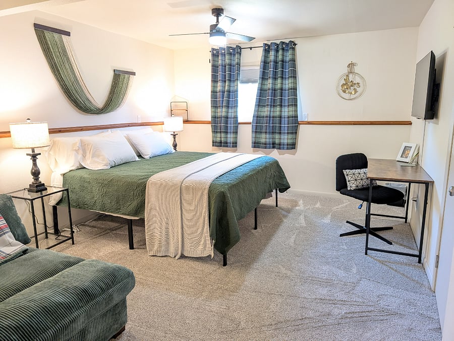 Primary basement bedroom has a king-size bed, 43" Roku Smart TV, a desk workspace, walk-in closet, connected to the basement bathroom.