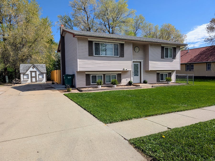 Exterior of split-level home with plenty of parking and key-code entry.