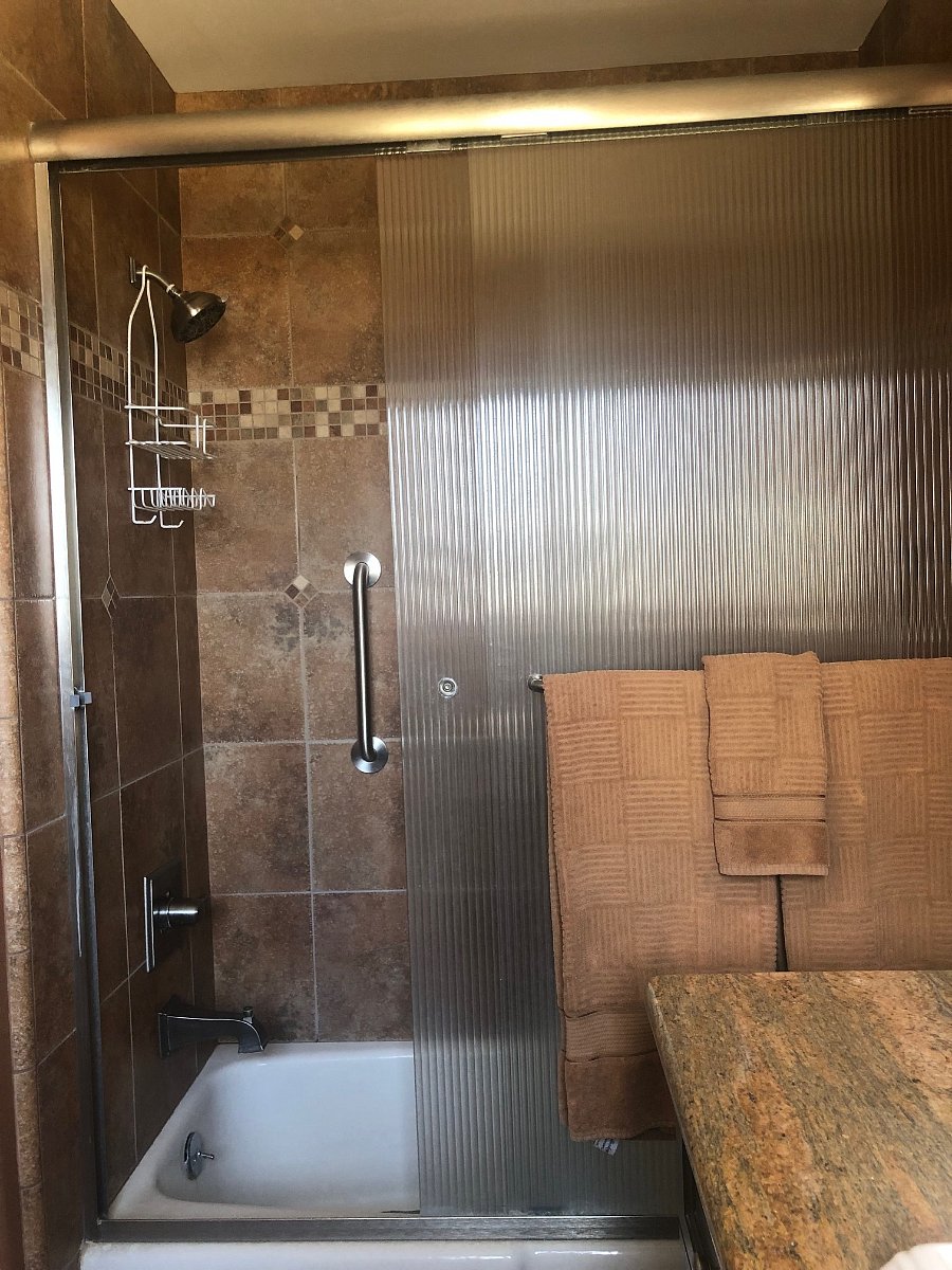 Full bath with tub/shower combo and vanity with storage.